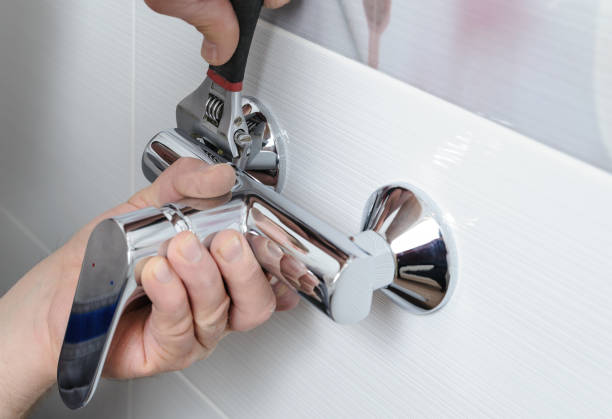 Mans hands fixing a shower faucet with a adjustable wrench