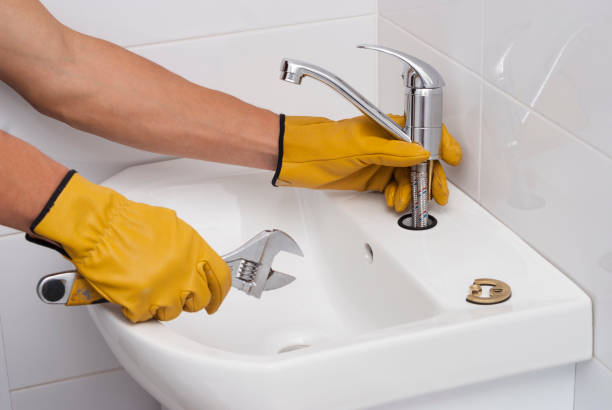 plumber installs a new faucet for a sink