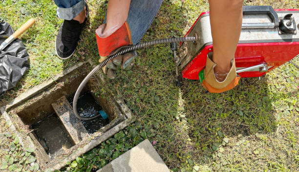 Clearing an outside drain blocked with fat with a electric plumbers snake